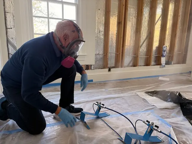A restoration technician setting drying equipment in a Spokane home stripped to the studs
